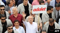 Turkish opposition leader Kemal Kilicdaroglu marches with a sign reading 'Justice.'