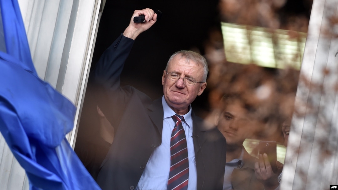 Serbian nationalist leader Vojislav Seselj waves at supporters after arriving at his Serbian Radical Party (SRS) headquarters in Zemun, near Belgrade, on November 12.