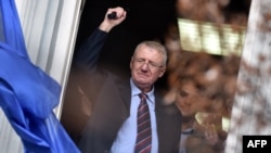 Serbian nationalist leader Vojislav Seselj waves at supporters after arriving at his Serbian Radical Party (SRS) headquarters in Zemun, near Belgrade, on November 12.