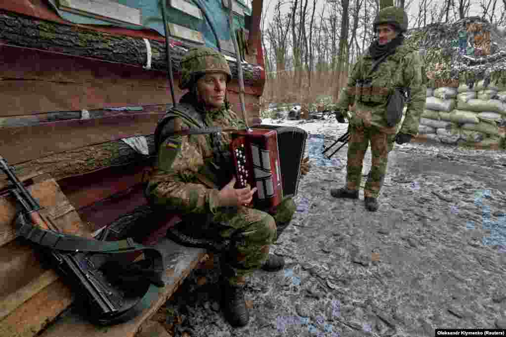 A Ukrainian service member plays music on the contact line with Russia-backed separatists in the Donetsk region of eastern Ukraine. (Reuters/Oleksandr Klymenko)