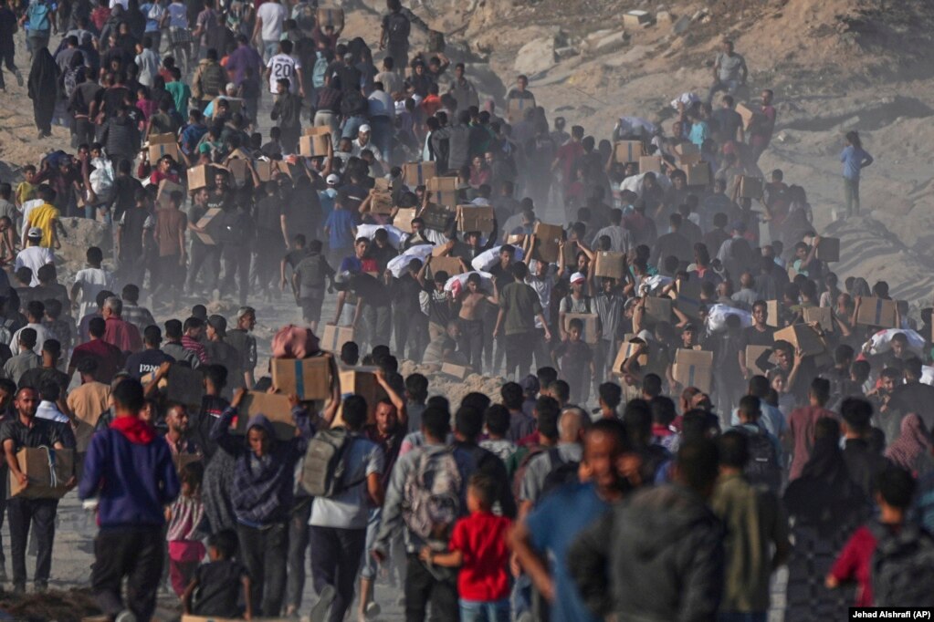 Turma palestinezësh duke bartur ndihmat e pranuara nga Programi Botëror i Ushqimit.