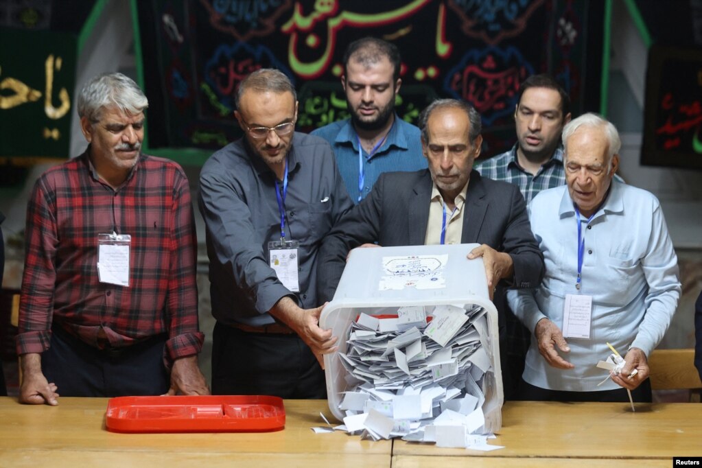 An electoral staff member empties a ballot box at a polling station on July 6 after voting ended in Iran's runoff presidential election. Pezeshkian's victory came amid a turnout of 49.8 percent, considerably higher than the record-low 40 percent in the first round of the election.