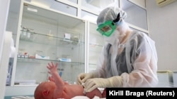 Медик ухаживает за новорожденным, заразившимся коронавирусом. Волгоград, 19 августа 2021 года