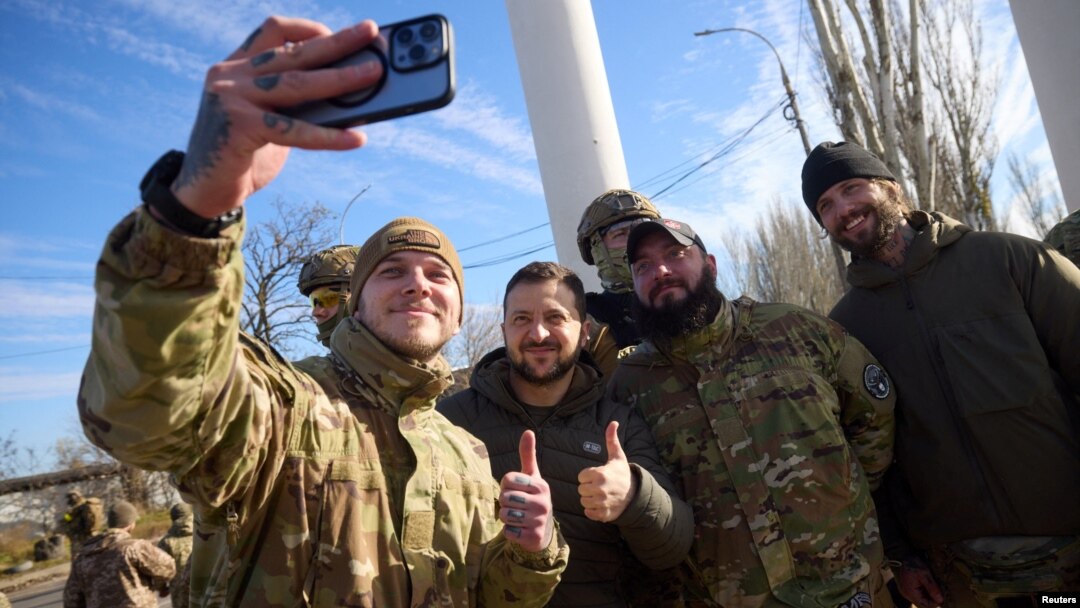 Președintele ucrainean Volodimir Zelenski face un selfie cu câțiva militari ucraineni în timpul vizitei surpriză de luni de la Herson, 14 noiembrie 2022.