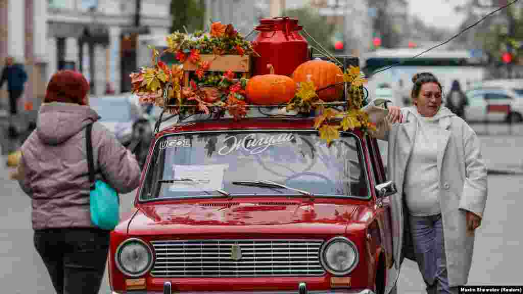 Žena pozira s retro automobilom VAZ 2101 tokom godišnjeg samita BRIKS-a u Kazanju u Rusiji.