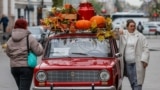 A woman poses with a retro VAZ 2101 car during the annual BRICS summit in Kazan, Russia.