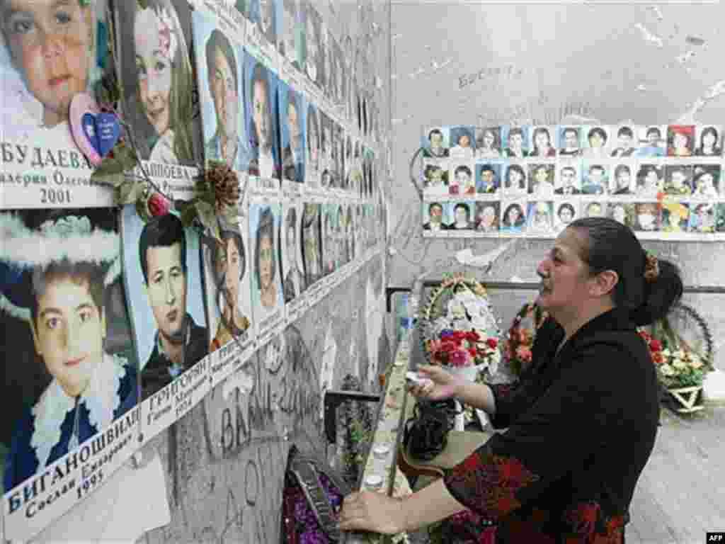 A woman looks at photos of the Beslan victims while visiting the ruined school in May (AFP) - Videos released last month appear to substantiate this claim. One shows Russian experts at the scene in the days that followed the massacre agreeing the explosion that launched the battle came from outside.