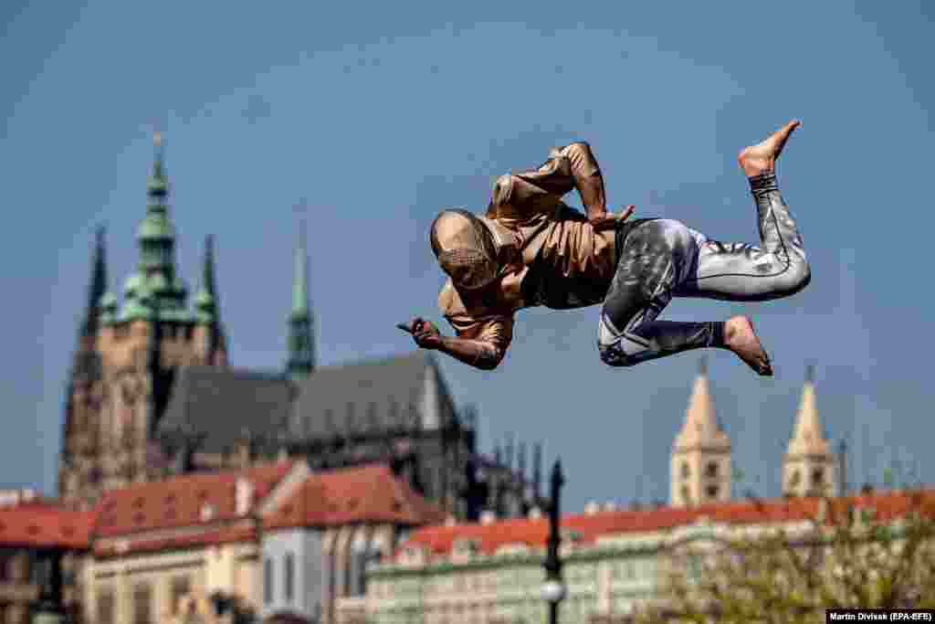 A member of the artistic group Cirk La Putyka performs on a trampoline in Prague on April 9. The aim of Cirk La Putyka events in the streets of the Czech capital is to get live art back to people during the coronavirus lockdown. (epa-EFE/Martin Divisek)