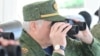 Аляксандар Лукашэнка глядзіць у бінокль, архіўнае фота