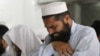 A man cries as he offers funeral prayers with others for the dead Taliban supreme leader Mullah Mohammad in Pakistan on July 31.