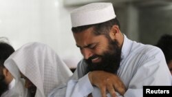 A man cries as he offers funeral prayers with others for the dead Taliban supreme leader Mullah Mohammad in Pakistan on July 31.