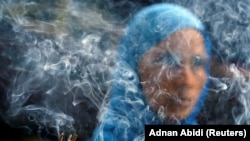 INDIA -- Smoke rises from burning incense sticks as a woman prays inside the shrine of Muslim Sufi Saint Nizamuddin Auliya in New Delhi, August 21, 2017