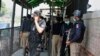 Pakistani police officers gather at a district court in Peshawar following the fatal shooting of a man accused of blasphemy on July 29. 