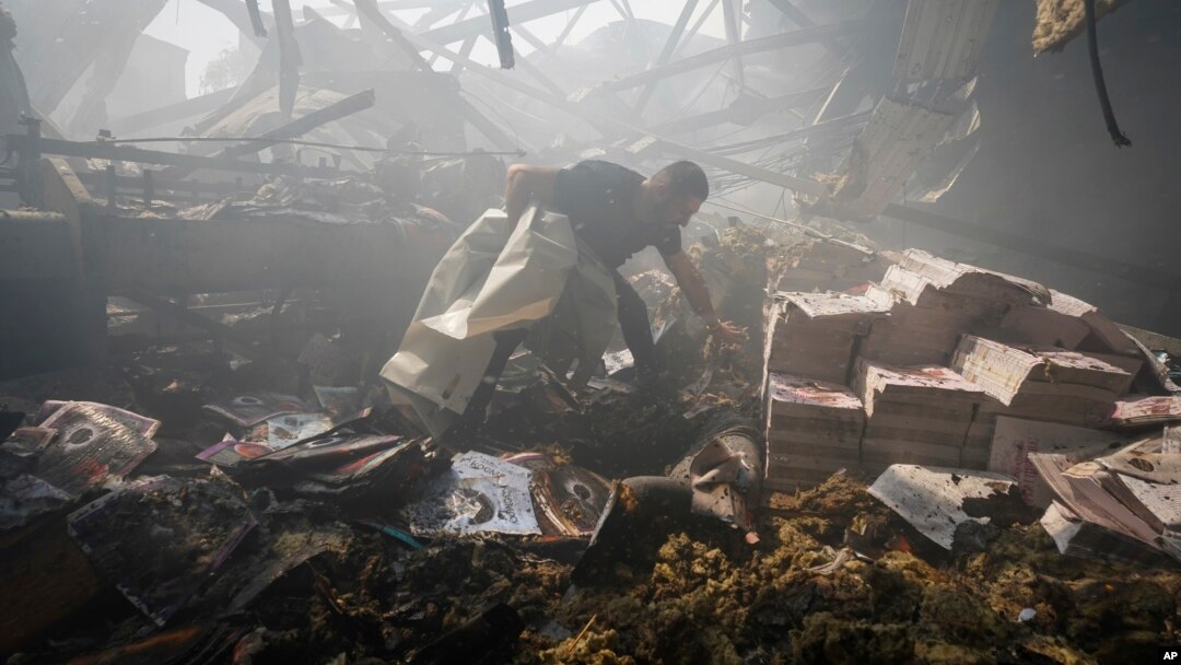 Un lucrător al serviciului de urgență al Ucrainei verifică o clădire grav avariată în urma unor bombardamente rusești. 