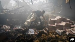 Un lucrător al serviciului de urgență al Ucrainei verifică o clădire grav avariată în urma unor bombardamente rusești. 