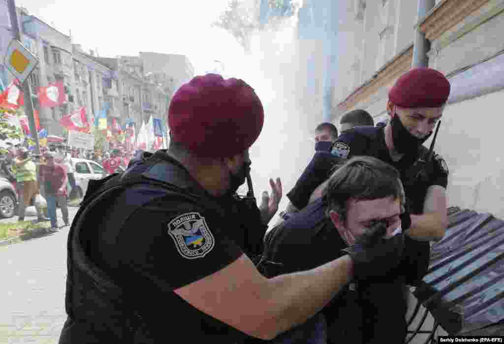 Ukrainian police officers detain a far-right militant who had allegedly attacked members and supporters of the Party of Shariy taking part in a protest rally in front of the Presidential Office in Kyiv on June 17. The activists supporting the conservative Euroskeptic party led by populist journalist Anatoly Shariy gathered under the slogan &quot;The dumb president&quot; as they lambasted Ukrainian President Volodymyr Zelenskiy for what they perceive as his failure to implement his election campaign promises. (epa-EFE/Sergei Dolzenko)