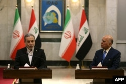 Iranian Foreign Minister Abbas Araqchi (left) and Iraqi Foreign Minister Fuad speak to reporters in Baghdad on July 28.