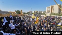 Protesters and militia fighters gather to condemn air strikes on bases belonging to Hashd al-Shaabi (paramilitary forces), outside the main gate of the U.S. Embassy in Baghdad. December 31, 2019