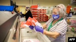 Election workers load ballots into a sorting machine on Election Day in Renton, Washington, on November 3, 2020.