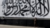  A man walks past a wall mural depicting the Taliban flag in Kabul.