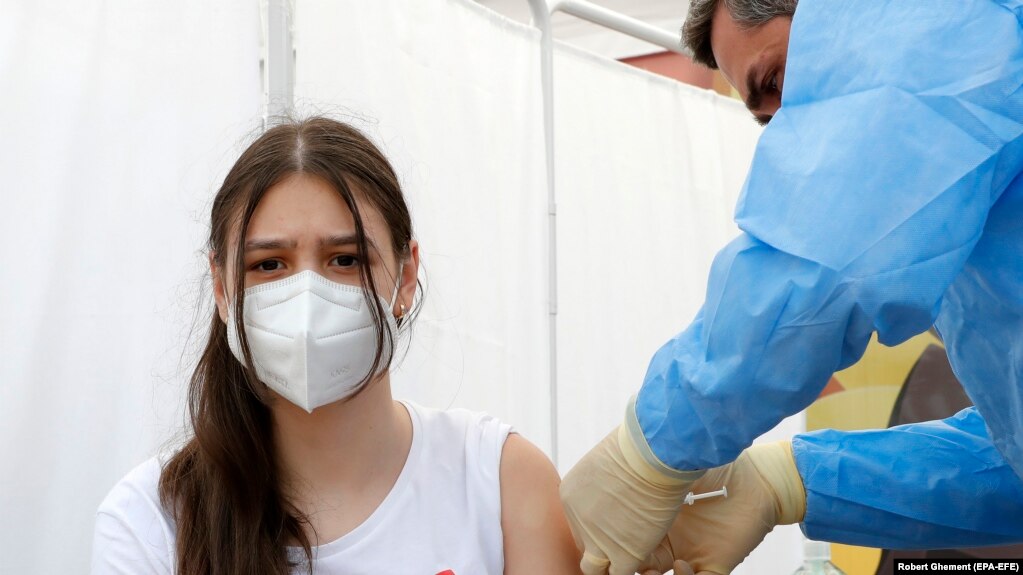 Një vajzë 14 vjeçe duke u vaksinuar kundër koronavirusit në Rumani.