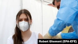 Një vajzë 14 vjeçe duke u vaksinuar kundër koronavirusit në Rumani.