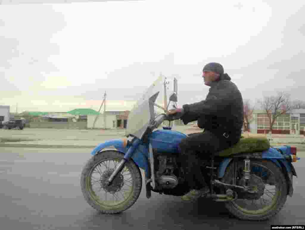 Motosikletde barýan bir adam.