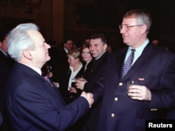 Slobodan Milošević i Vojislav Šešelj rukuju se na prijemu tokom kongresa socijalista na kojem je Milošević ponovo izabran za predsednika stranke, februara 2000. godine. Osam meseci kasnije Milošević je srušen.