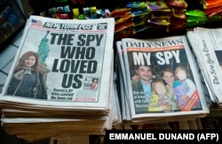 Un chioșc de ziare din New York, în 2010: fotografiile presupușilor spioni ruși Anna Chapman (stânga) și Richard și Cynthia Murphy.