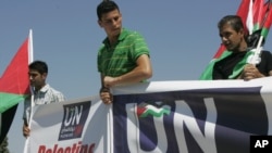 Activists hold banners in front of UN headquarters as they deliver a letter addressed to Secretary-General Ban Ki-moon in the West Bank city of Ramallah on September 8.