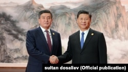 Қырғызстан президенті Сооронбай Жээнбеков (сол жақта) пен Қытай президенті Си Цзиньпин. Циндао, 10 маусым 2018 жыл.