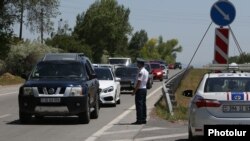 Armenia -- A police officer monitors cars entering Yerevan to see if their drivers and passengers wear face masks, June 1, 2020. 