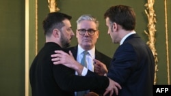 Ukrainian President Volodymyr Zelenskyy, UK Prime Minister Keir Starmer, and French President Emmanuel Macron embrace after holding a meeting during a summit in London on March 2.