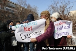 Людей с плакатами на английском языке «Активисты не экстремисты» и «Свободу политзаключенным» уводят с места предполагаемого митинга оппозиции. Алматы, 28 февраля 2021 года