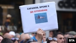 Протестиращ срещу временния главен прокурор Борислав Сарафов държи плакат с негова снимка, на която той е легнал на падъл борд, София, 22 юли 2025 г.