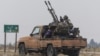 A rebel fighter sits on the back of a vehicle in the countryside of Homs Province amid a lightning offensive by forces opposed to authoritarian Syrian President Bashar al-Assad on December 7. 