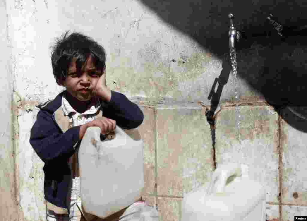 A Yemeni boy fills up a jug of water in Sanaa where water supplies are under considerable strain. (Reuters/Mohamed al-Sayaghi)