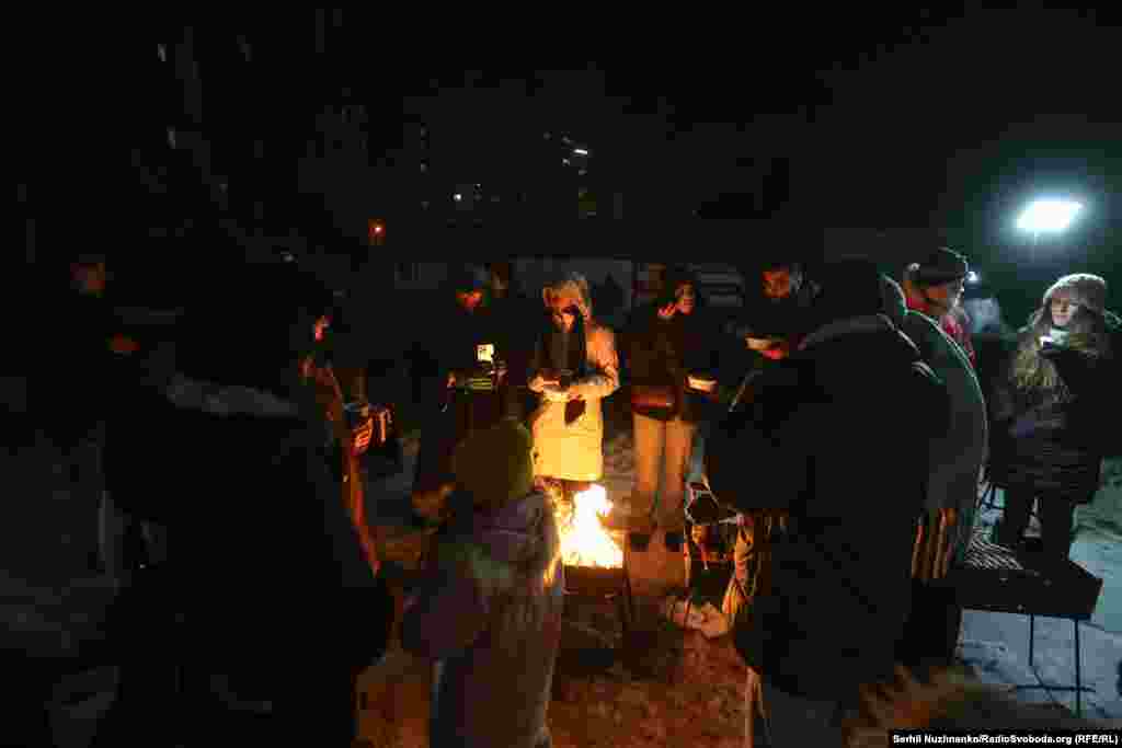 Люди гріються біля вогнища