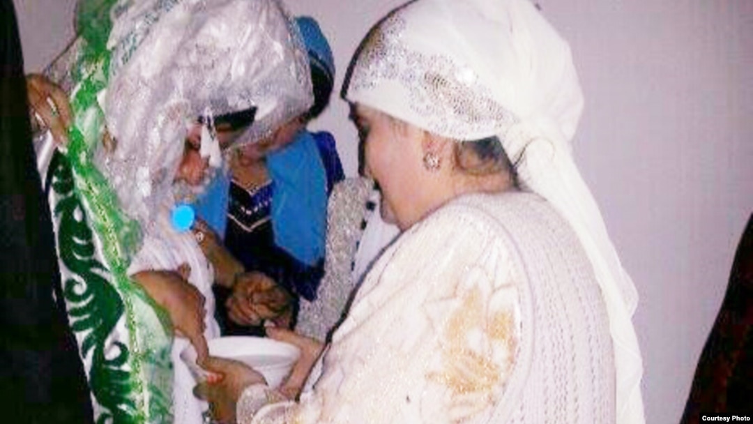 Shahnoza Idrisova (left) and her new mother-in-law perform a wedding ritual during her Internet nuptials last month. 