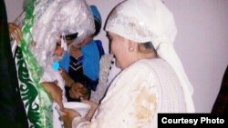 Shahnoza Idrisova (left) and her new mother-in-law perform a wedding ritual during her Internet nuptials last month. 