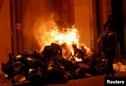 Manifestând împotriva reformei pensiilor, protestatarii de la Paris au incendiat grămezi de gunoi.