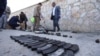 Afghan security officials inspect the scene of an attack by militants outside the Interior Ministry building in Kabul on May 30