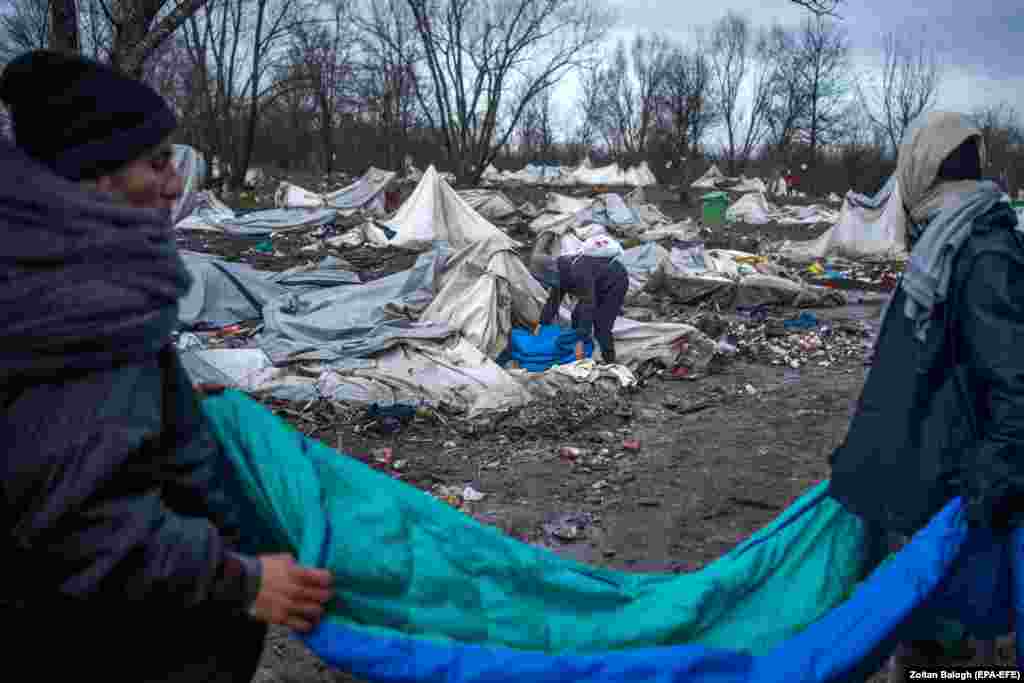 Migrants collect usable objects in a vacated campsite at Vucjak, northwestern Bosnia, on December 11, 2019. On the previous day, Bosnian authorities evacuated the camp due to the lack of running water and other facilities. (epa-EFE/Zoltan Balogh)