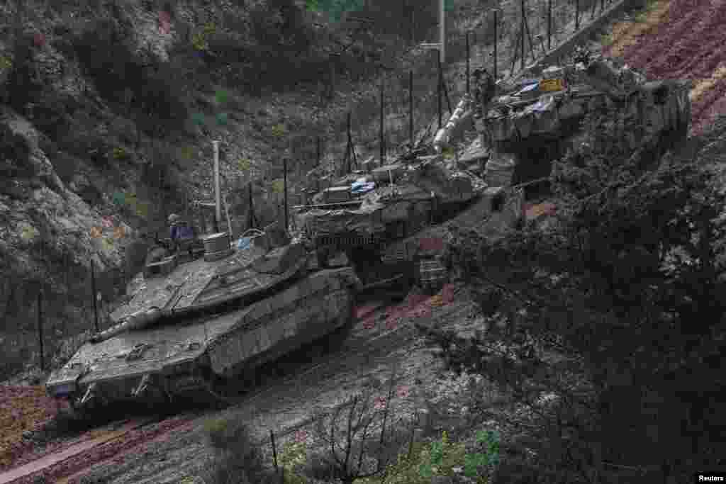 Израильские солдаты выглядывают из танка, чтобы осмотреть застрявший в грязи танк на израильской стороне границы с Ливаном, на севере Израиля, 21 марта 2026 года. REUTERS/Tyrone Siu