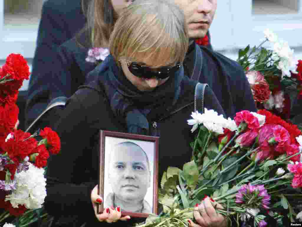 A woman carries a portrait of Belarusian journalist Aleh Byabenin during his funeral in Minsk on September 6. Belarus's opposition has rejected a police statement that the death of Byabenin, the director of one of the country's most prominent opposition media outlets, was suicide, saying he had no reason to kill himself. Photo by Vasily Fedosenko for Reuters