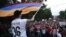 A demonstrator waves an Armenian flag as others shout slogans during a protest against an increase of electricity prices in Yerevan on June 25.