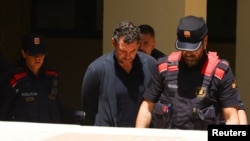 Джонатан Андик в сопровождении полицейских