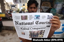 A man reading a newspaper about the Taliban taking over Kabul in Karachi, Pakistan.