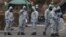 Military personnel wearing protective coveralls work to remove vehicles from a cordoned off area behind a police station in Salisbury following an attack on a former Russian spy by a nerve agent, which has now been identified as Novichok. 