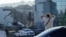 A resident looks on as rescuers work at the site of a shopping center hit by a Russian drone attack the day before in the Ukrainian city of Kryviy Rih, on August 22.